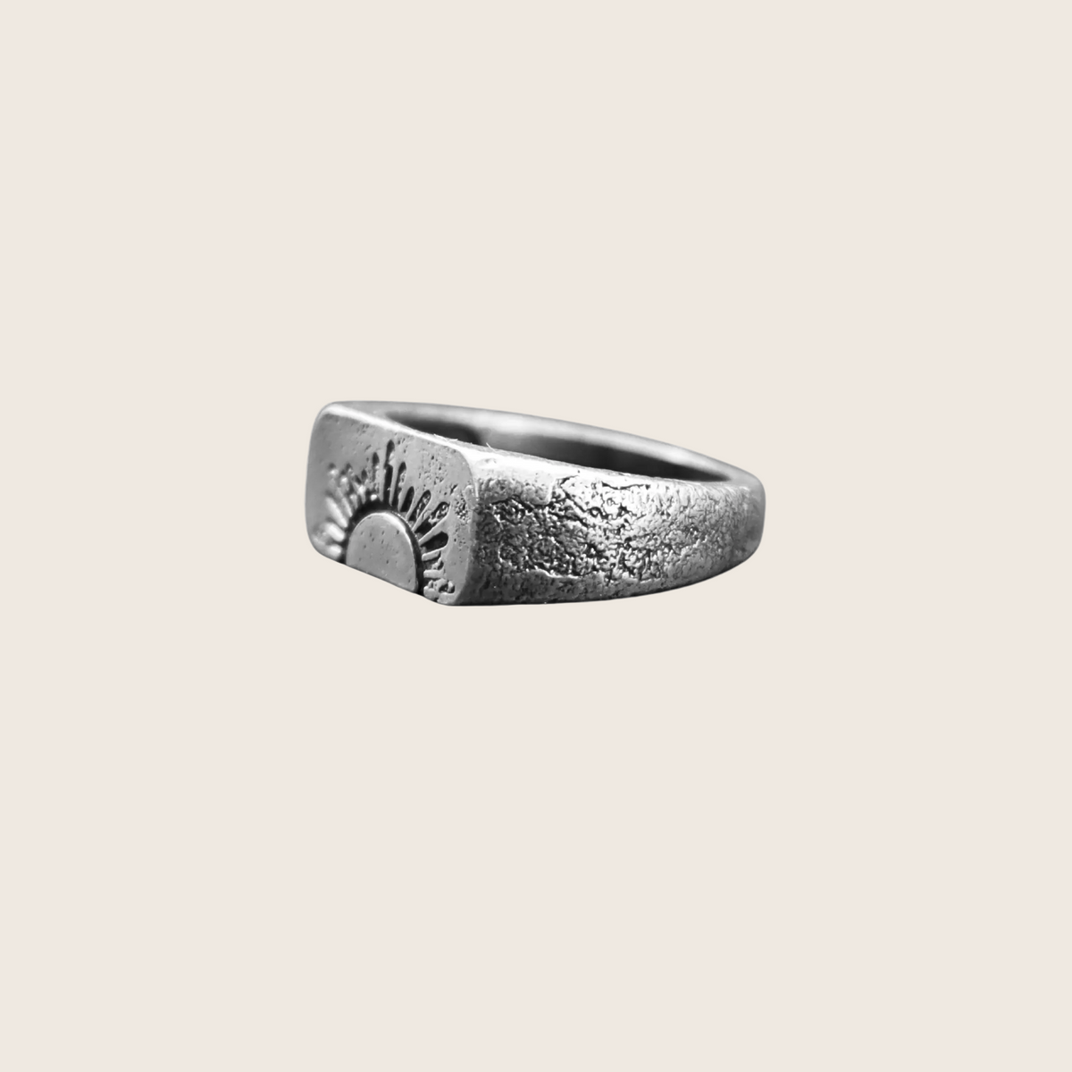 Silver ring with engraved design on a white background